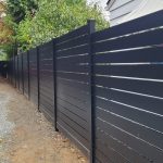 Modern horizontal aluminum fence with evenly spaced gaps installed next to a residential home in Shoreline, WA