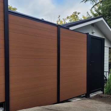 Brown composite privacy fence with black aluminum frame and black entry gate