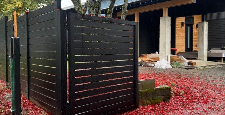 Black aluminum privacy fence with horizontal slats and matching driveway gate in Shoreline, WA
