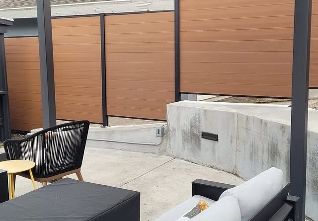 Composite horizontal slat privacy fence surrounding outdoor seating area
