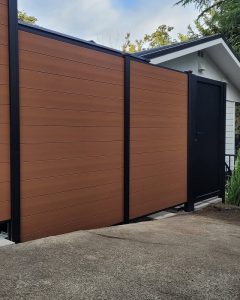 Horizontal brown composite privacy fence with black aluminum gate in Mercer Island