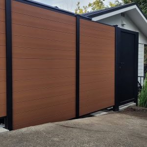 Horizontal brown composite privacy fence with black aluminum gate in Mercer Island