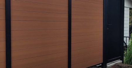Horizontal brown composite privacy fence with black aluminum gate in Mercer Island