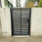 Black horizontal slat metal gate installed between concrete walls in Bellevue, WA